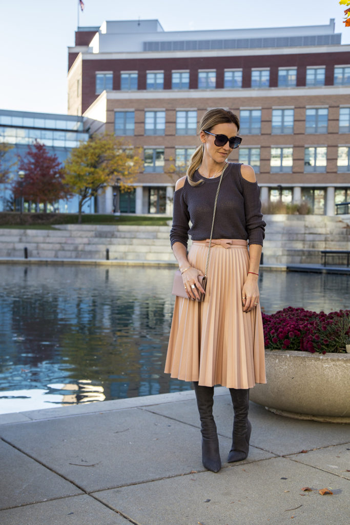 Holiday outfit ideas featured by top Indianapolis fashion blogger, Karina Style Diaries: image of a woman by the river, wearing a Zara pink Pleated Skirt, and a Free People cold shoulder sweater 