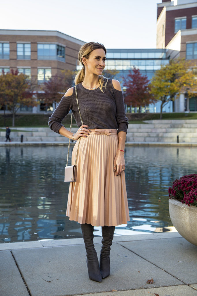 Holiday outfit ideas featured by top Indianapolis fashion blogger, Karina Style Diaries: image of a woman by the river, wearing a Zara pink Pleated Skirt, and a Free People cold shoulder sweater 