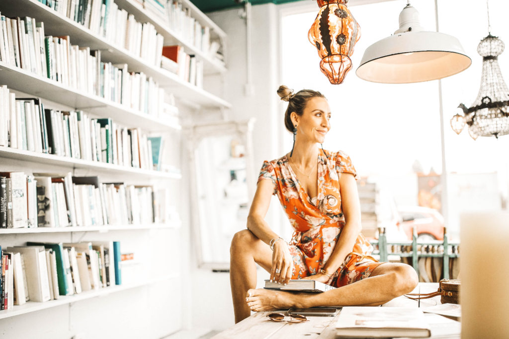 seating on the table reading books - Spring Essentials: Lulus Dresses, Shorts, Top and Jumpsuit featured by popular Indianapolis fashion blogger, Karina Style Diaries