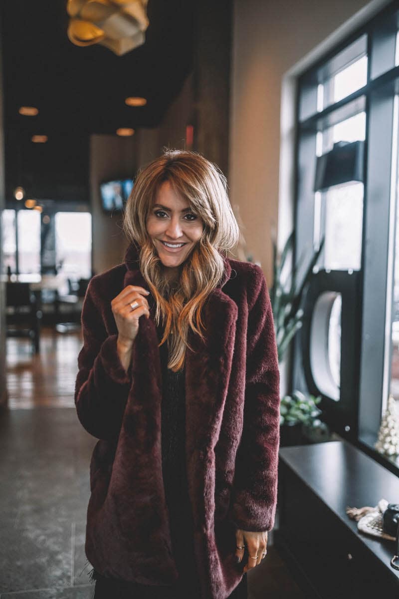 ASTR the label faux fur chloe coat | Holiday Party look featured by top Indianapolis fashion blogger, Karina Style Diaries: image of a woman wearing a Lesley Jane black fringe dress, Manolo Blahnik heels, Chanel bubble bag, Daniel Wellington watch and Jemma Sands drop earrings