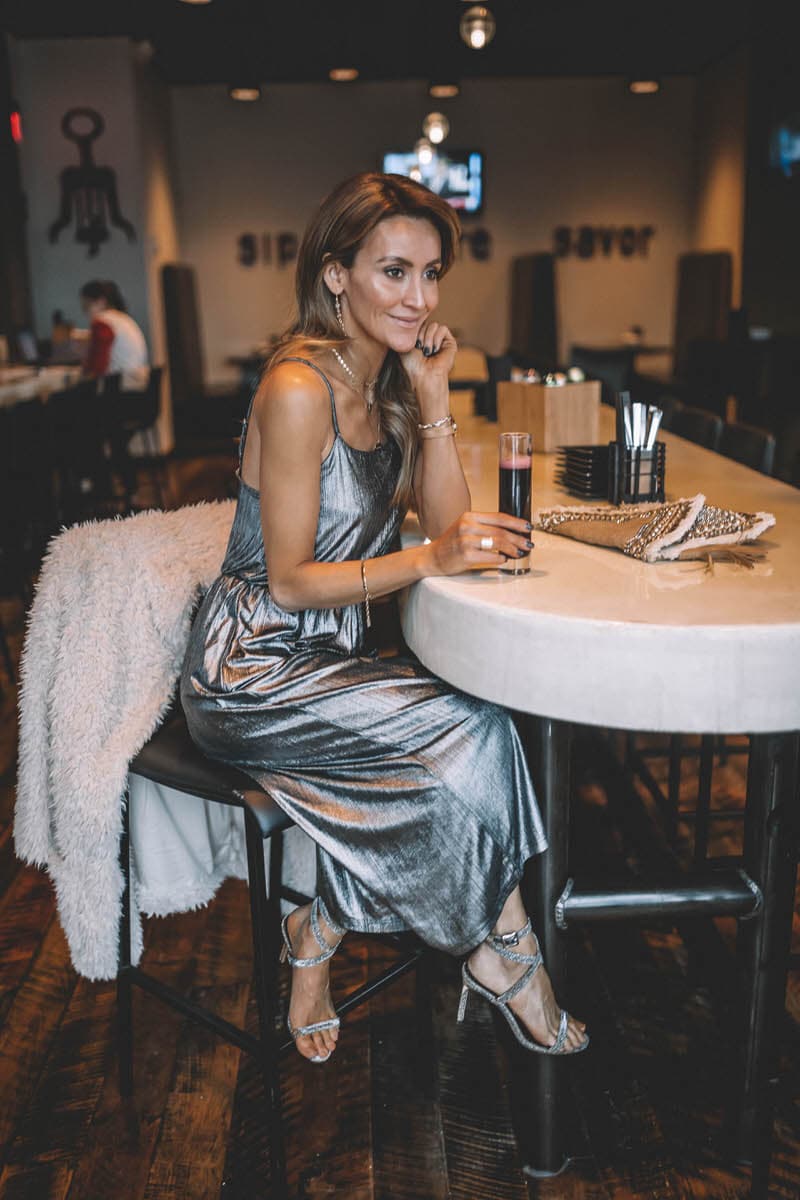 Top Indianapolis fashion blogger, Karina Style Diaries, features the perfect Holiday look with a BB Dakota metallic Jumpsuit: image of a blonde woman wearing a BB Dakota metallic jumpsuit, a BB Dakota faux fur coat, a Sashi clutch and Manolo Blahnik silver heels