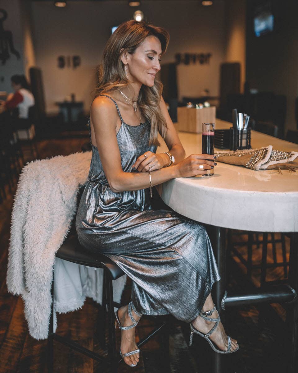 Top Indianapolis fashion blogger, Karina Style Diaries, features the perfect Holiday look with a BB Dakota metallic Jumpsuit: image of a blonde woman wearing a BB Dakota metallic jumpsuit, a BB Dakota faux fur coat, a Sashi clutch and Manolo Blahnik silver heels