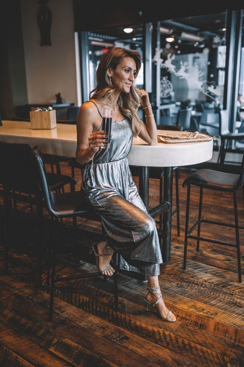 Top Indianapolis fashion blogger, Karina Style Diaries, features the perfect Holiday look with a BB Dakota metallic Jumpsuit: image of a blonde woman wearing a BB Dakota metallic jumpsuit, a BB Dakota faux fur coat, a Sashi clutch and Manolo Blahnik silver heels