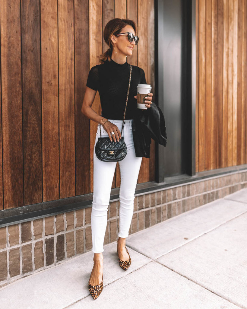 Karina Reske wearing white skinny jeans black bodysuit chanle buble crossbody leopard shoes pointy flats leather suede moto jacket black and white chic outfit idea