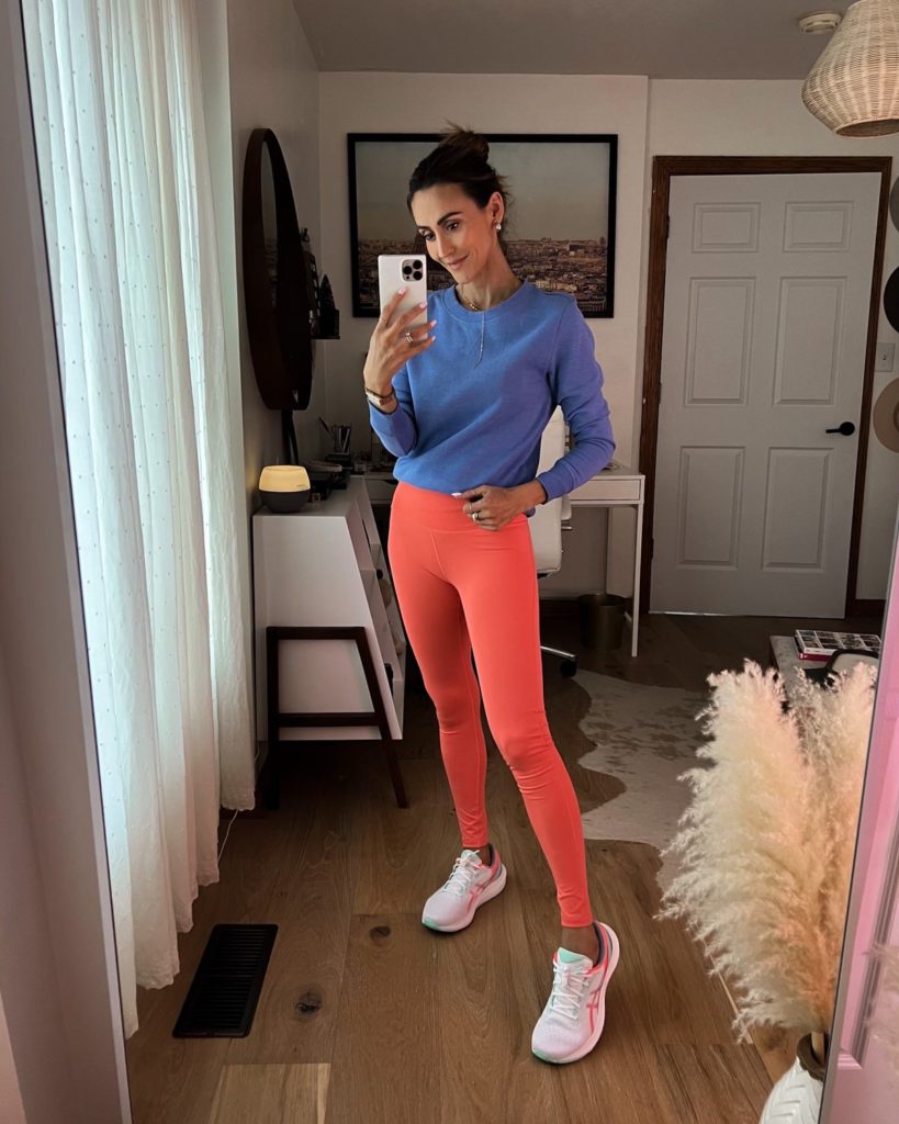 karina wears coral amazon leggings and blue crewneck sweatshirt and asics sneakers