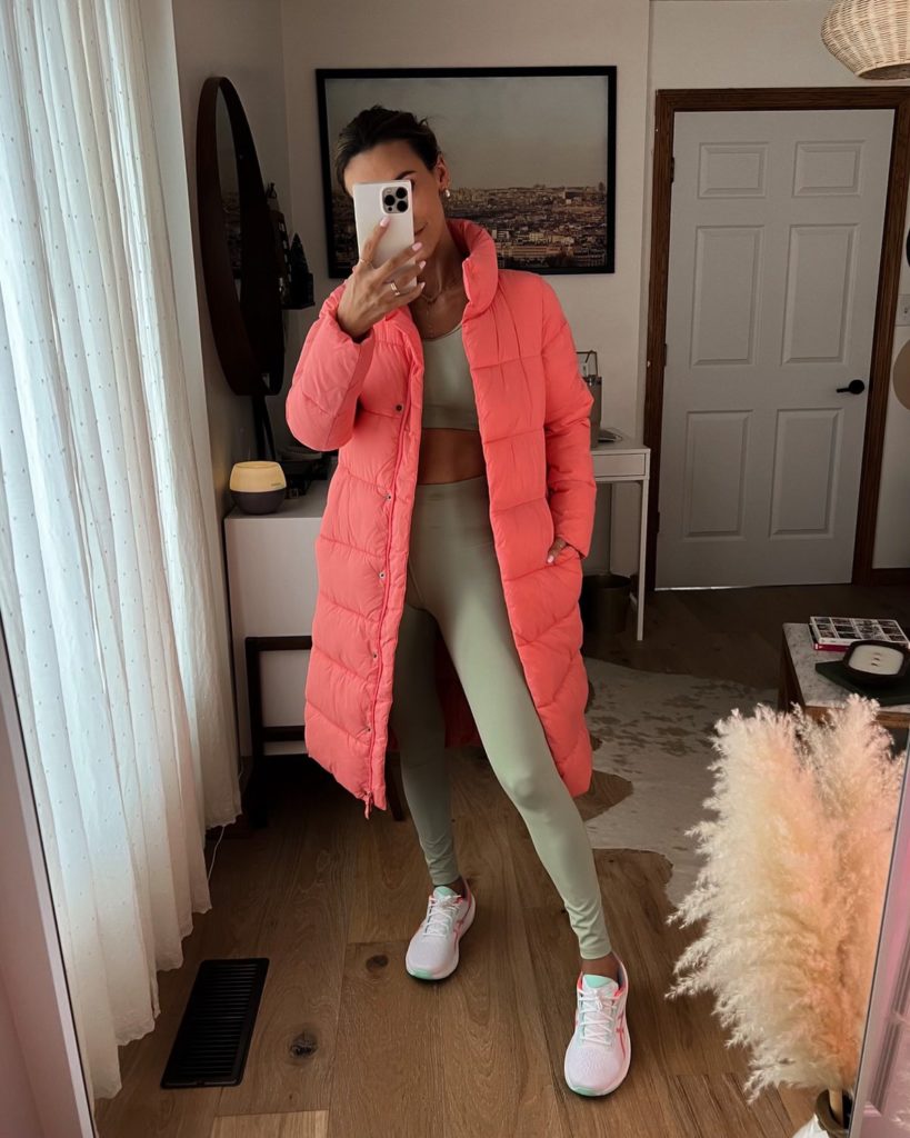 karina wears green amazon workout set with pink puffer coat and asics sneakers