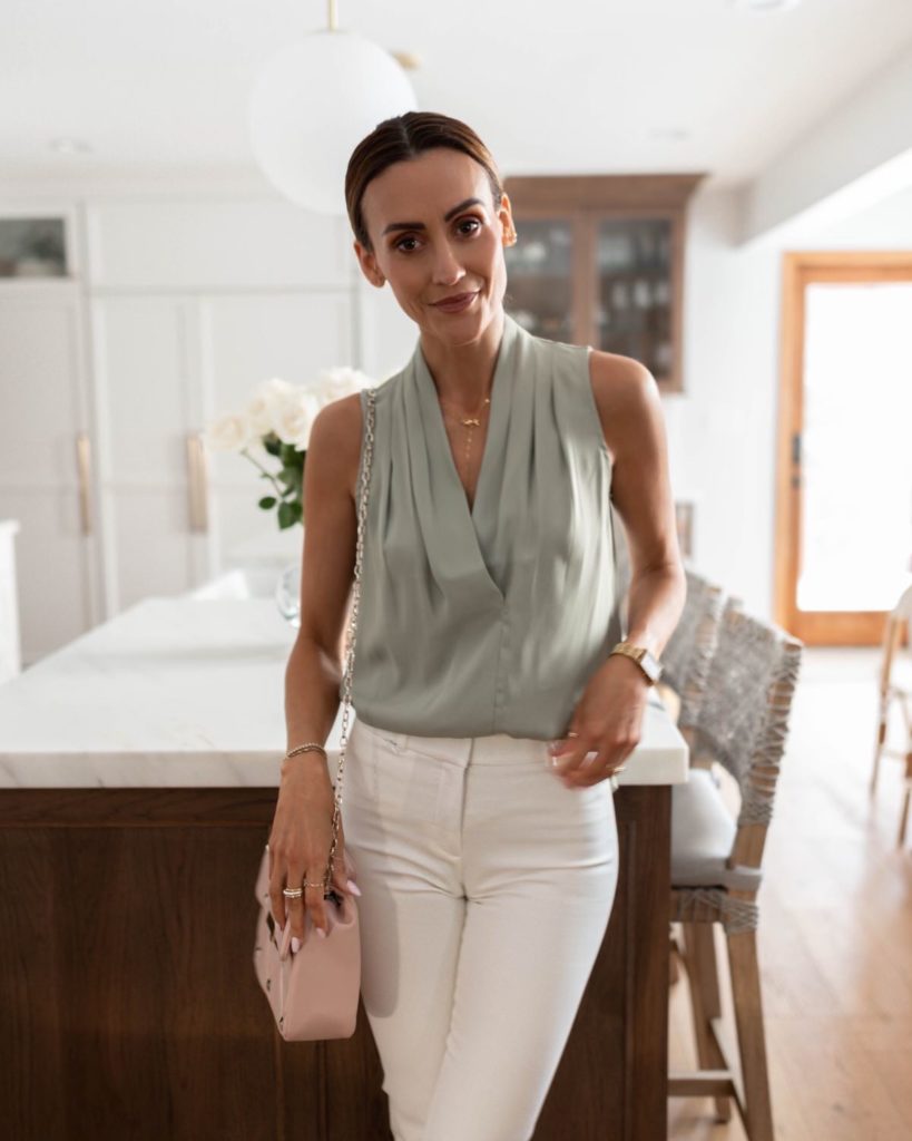 Karina wears white house black market sage top with white pleated pant and white blazer