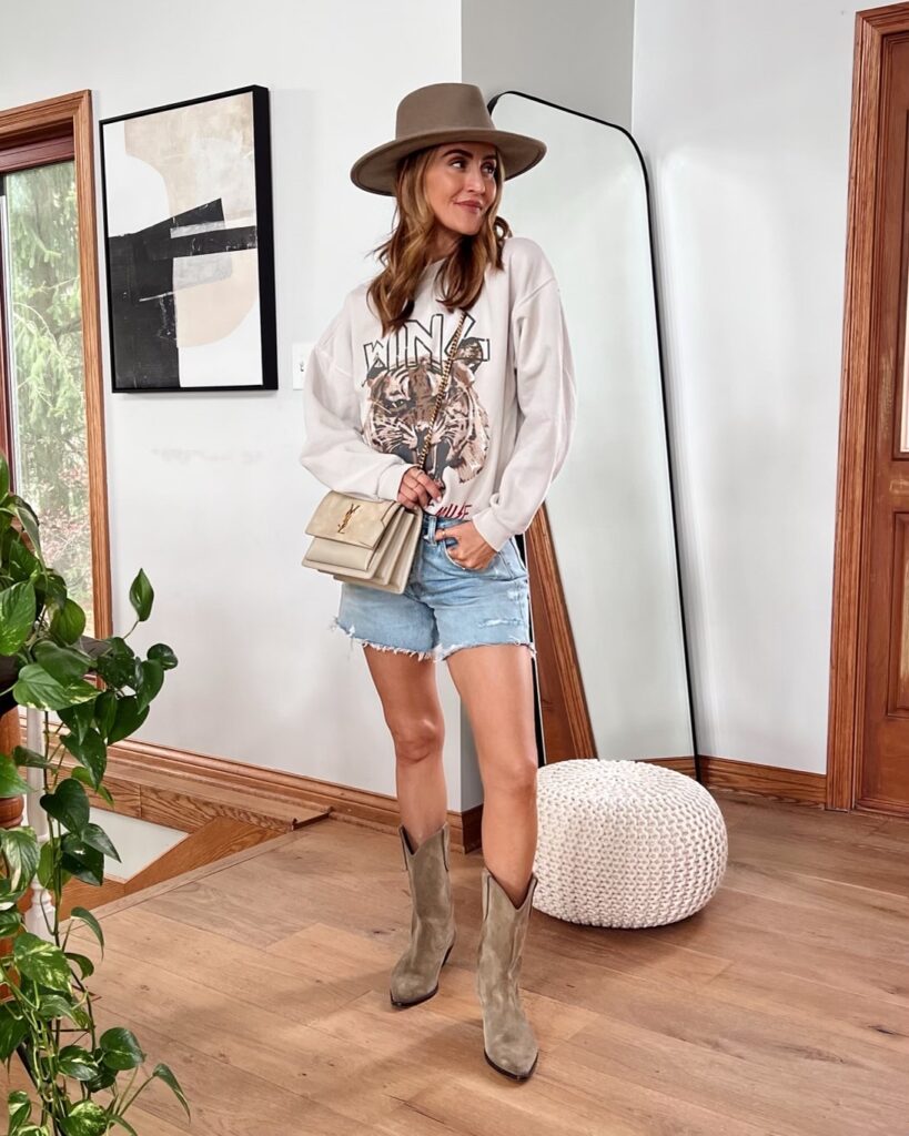 Karina wears agolde denim shorts with anine bing sweatshirt and isabel marant boots and ysl bag