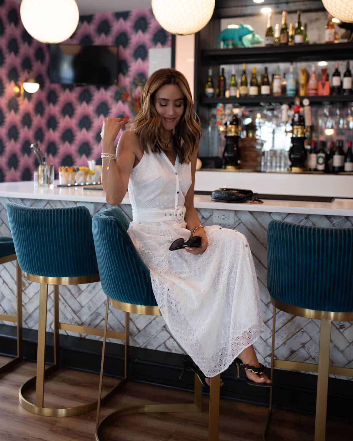 Karina wears white house black market white eyelet midi dress with black sandals and handbag