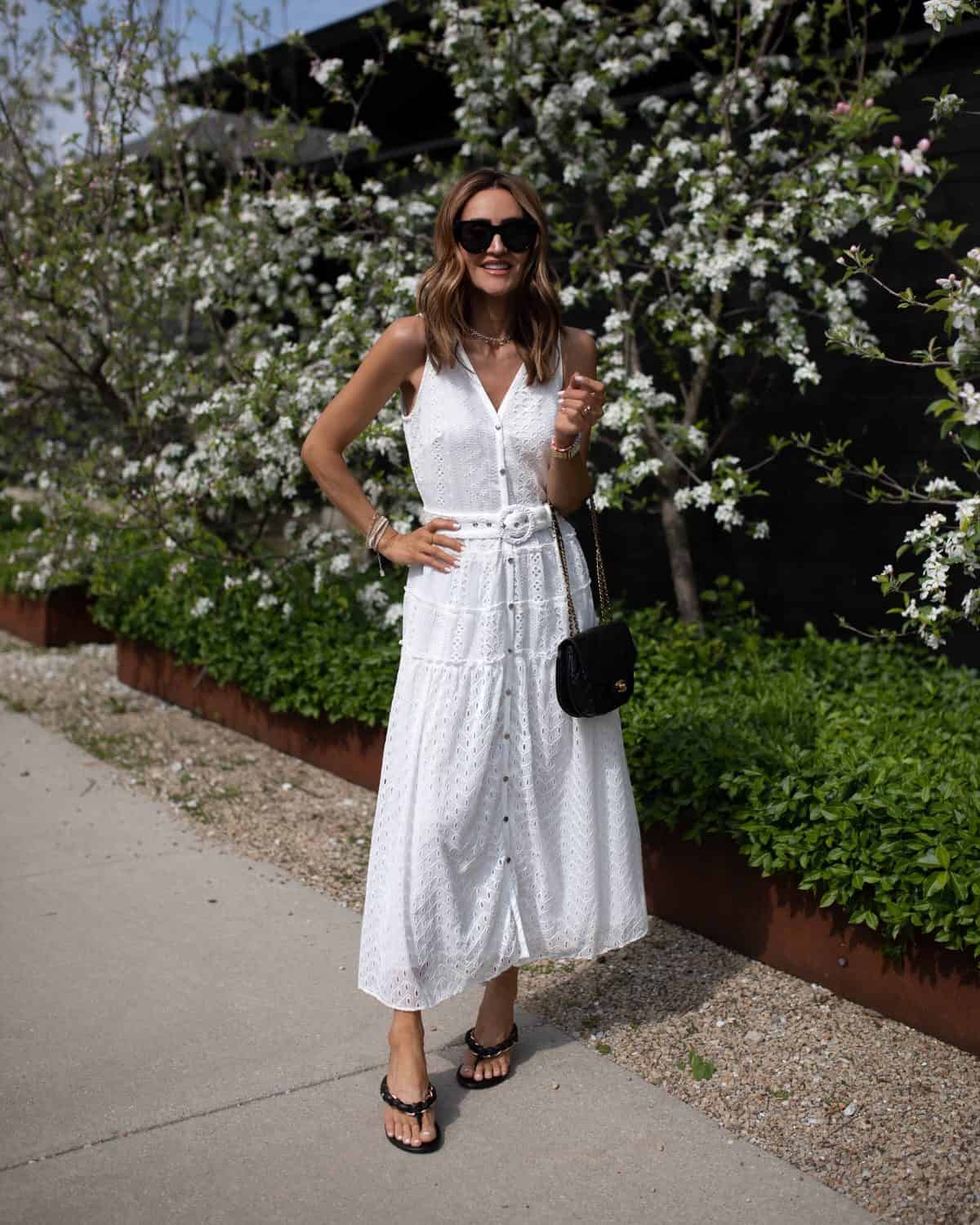 Karina wears white house black market white eyelet midi dress with black sandals and handbag