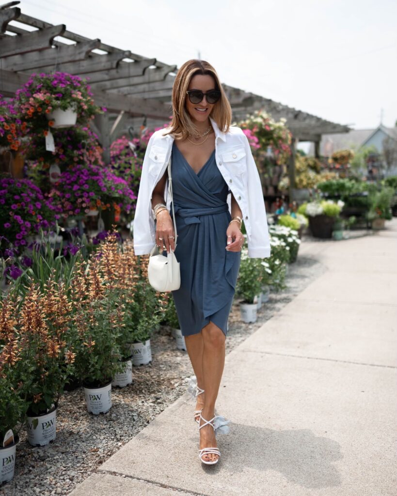 karina wears white house black market blue jersey knit wrap dress with white denim jacket