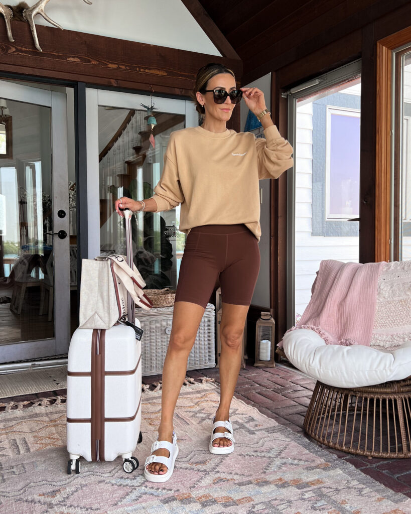 karina wears brown girlfriend biker shorts with tan sweatshirt and chloe tote bag