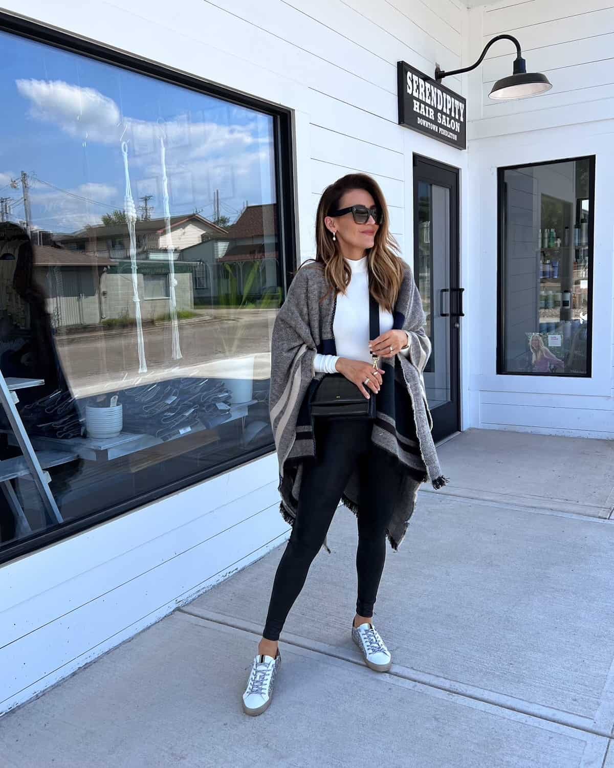 Karina wears Walmart oversized poncho with bodysuit and faux leather leggings
