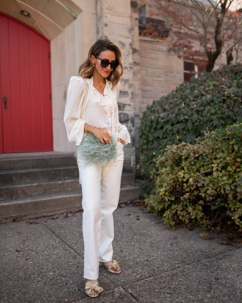 Karina wears agolde white leather pants with white top and feather bag