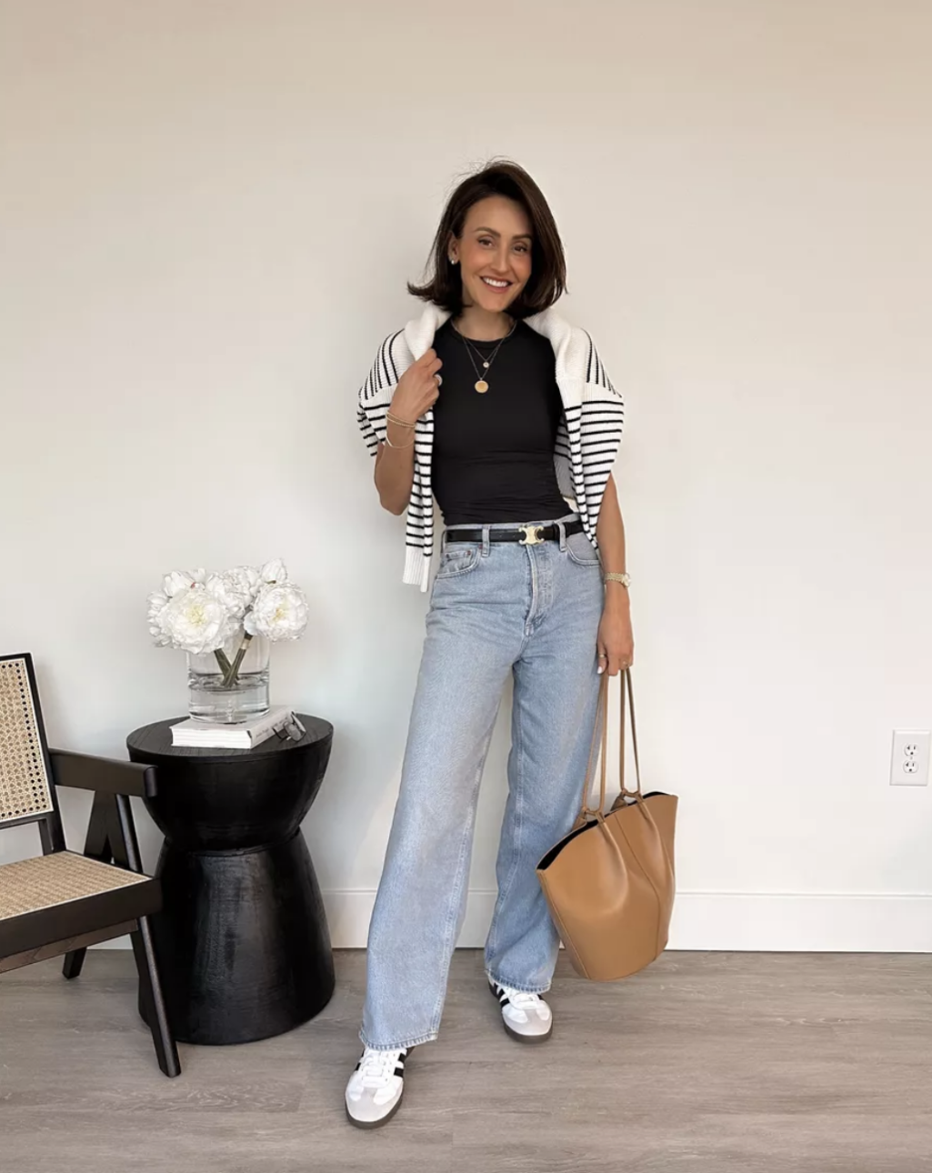 zip up sweatshirt over shoulders with jeans and a black t-shirt