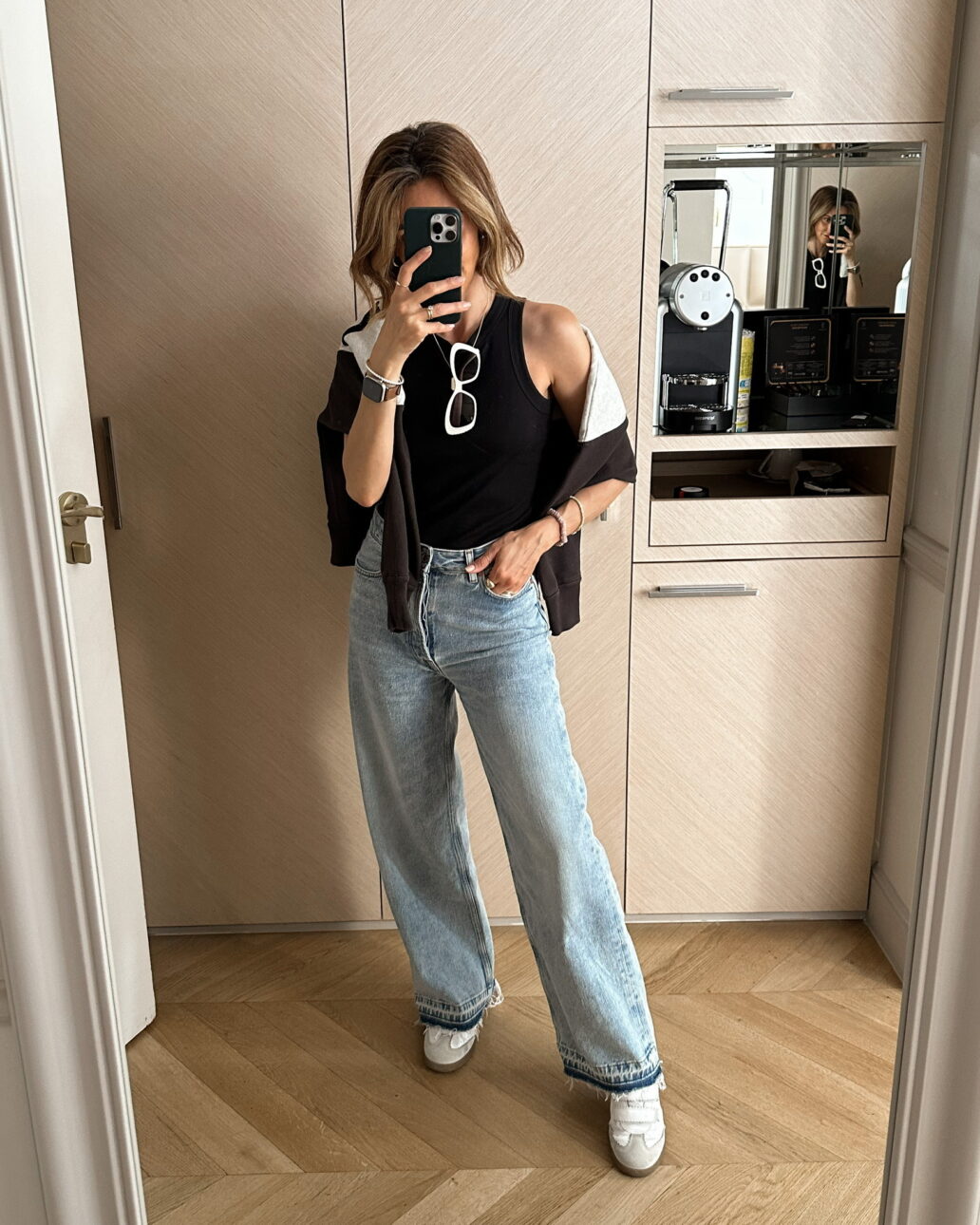 what to wear while shopping in Paris - jeans, white sneakers, black tank, and a cardigan