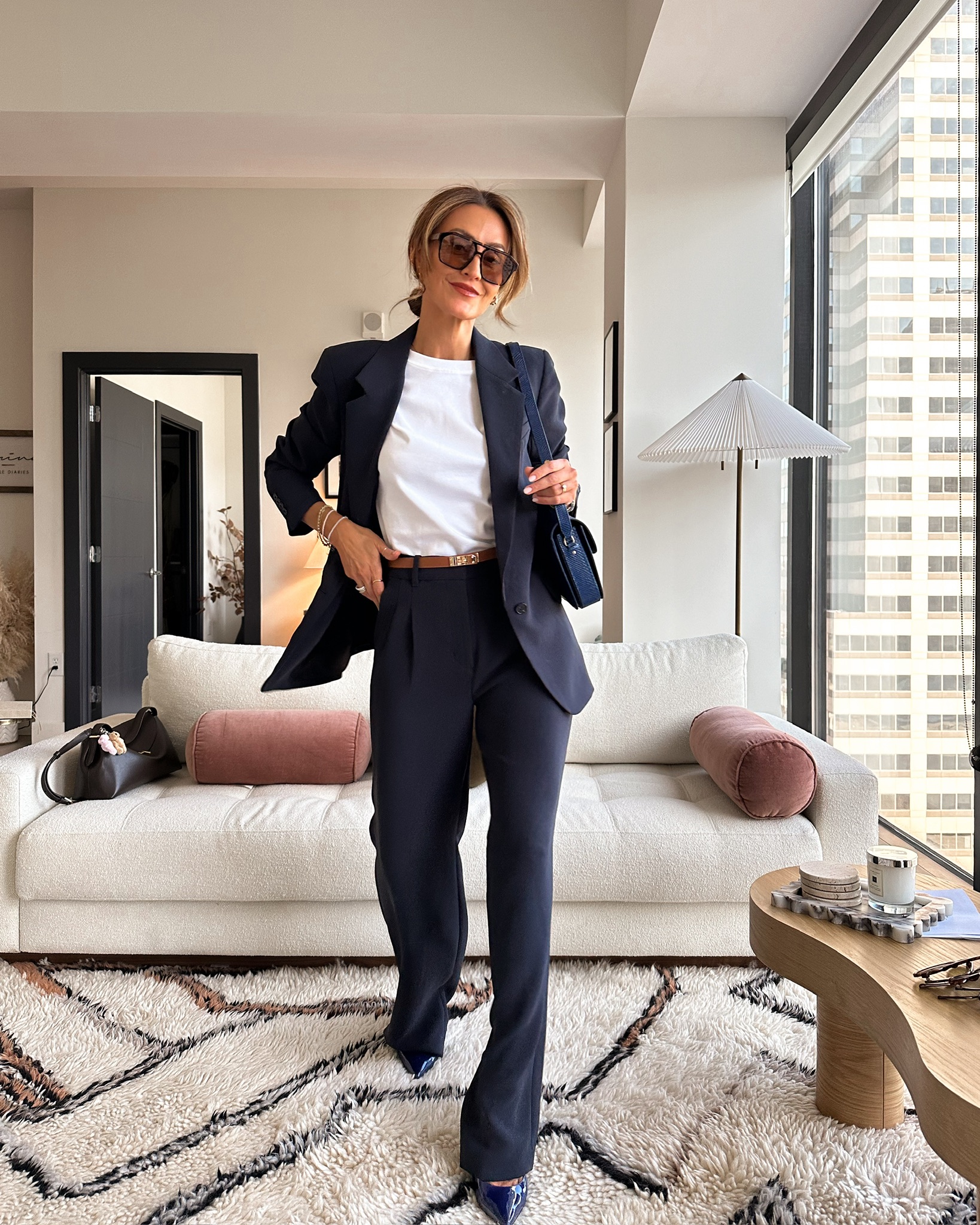 a white tee shirt and navy trousers with sunnies