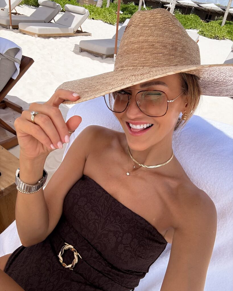 one piece swimsuit and straw sun hat outfit on the beach in a lounge chair