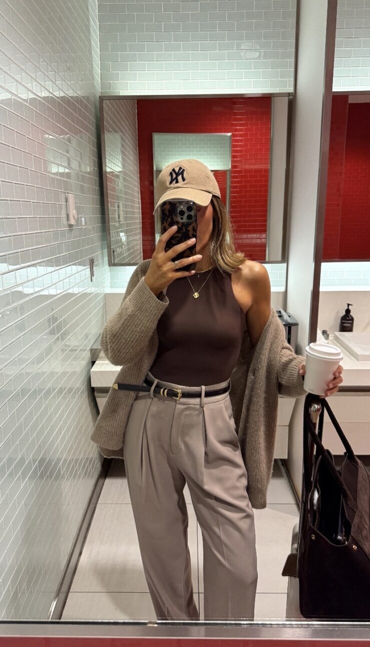 trouser airport outfit with a cardigan and baseball cap