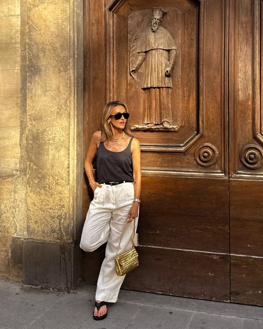 black loose knit tank, white linen pleated trousers, platform thong sandals, Celine aviator sunglasses, woven gold shoulder bag, gold buckle black leather belt, summer chic outfit